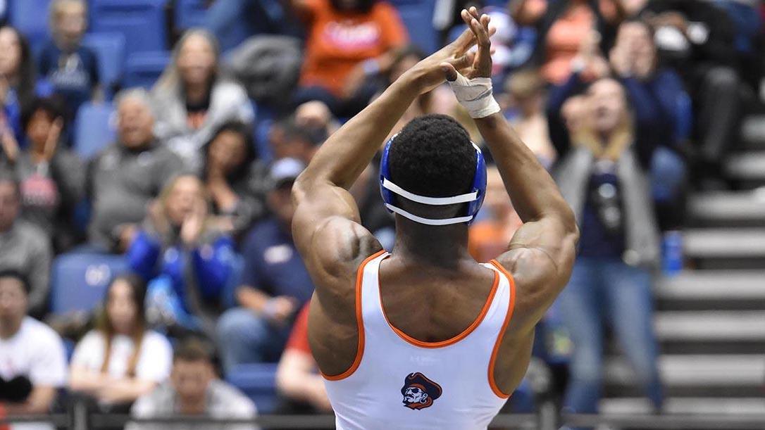 Marauders wrestling athlete clapping in front of crowd at a wrestling competition.